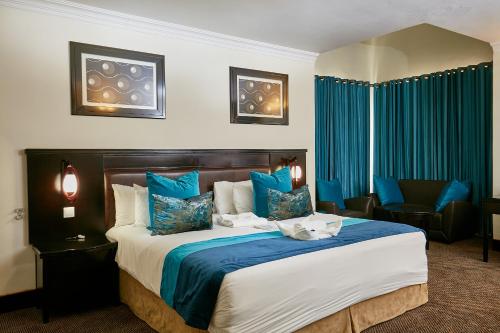 a hotel room with a large bed with blue pillows at Majestic Five Hotel in Palatswe