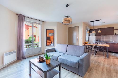 uma sala de estar com um sofá e uma mesa em Appart'City Classic Toulouse Saint-Simon em Toulouse