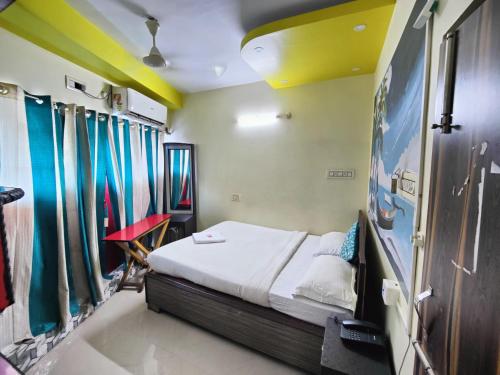 a bedroom with a bed in a room with curtains at Ruby's Inn in Kolkata