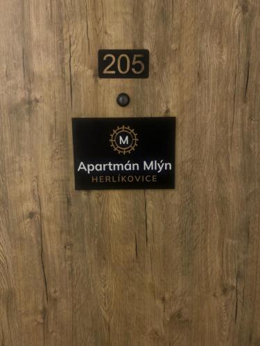 a sign on the front of a wooden door at Apartmán Mlýn Herlíkovice 205 in Vrchlabí