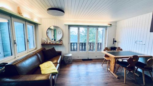 sala de estar con sofá y mesa en Chalet Tännli - CharmingStay, en Flumserberg