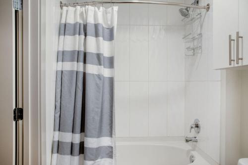 eine Badewanne mit Duschvorhang im Bad in der Unterkunft Bellevue jr 1br w lounge gym nr coffee shops SEA-612 in Bellevue