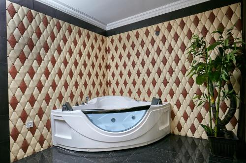 a bath tub in a room with a wall at Majestic Five Hotel in Palatswe