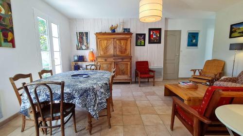 un salon avec une table et une salle à manger dans l'établissement Dans le centre du village de La Couarde, charmante ville de plain pied, à La Couarde-sur-Mer