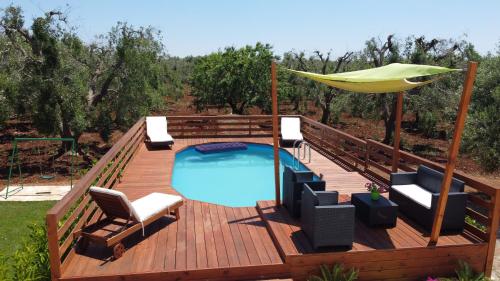 a deck with a pool and a hammock on it at villa Antony in San Michele Salentino