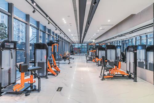 a gym with rows of exercise equipment and windows at Wenzhou Hangbin International Hotel in Wenzhou