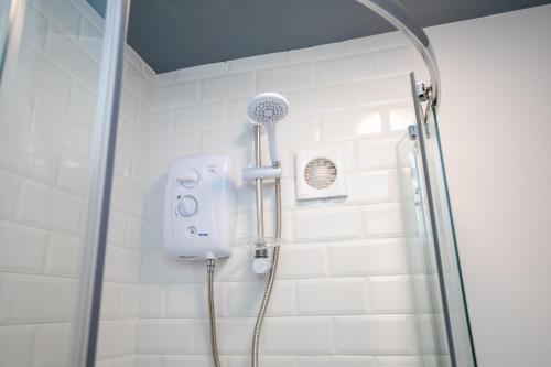 a shower with a shower head in a bathroom at 59a Thorne Road Apartments in Doncaster