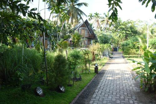a path in front of a house with trees and plants at Steps Garden Resort in Negombo
