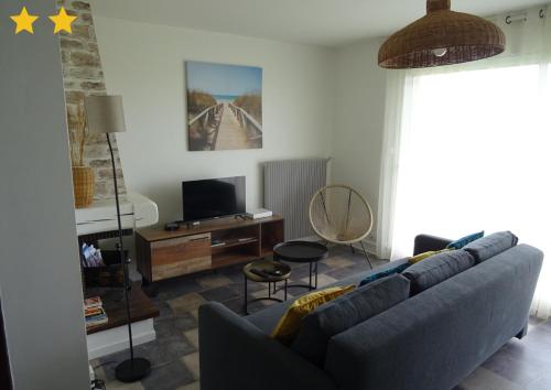 un salon avec un canapé et une télévision dans l'établissement La Digue, à Calais