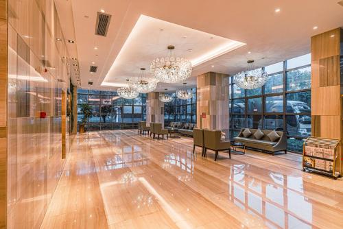 a lobby with chairs and chandeliers in a building at Wenzhou Hangbin International Hotel in Wenzhou