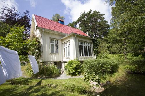 a small house with a red roof in a yard at Torpet Mon in Gothenburg