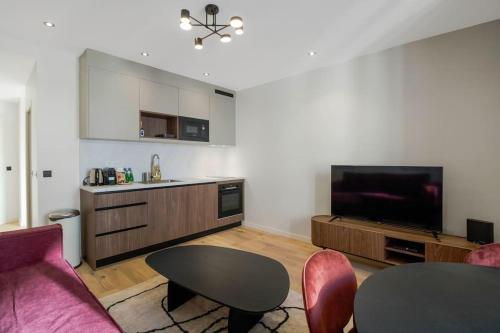 un salon avec un canapé, une table et une télévision dans l'établissement 41.Appart 4Pers#1 Bedroom #Père Lachaise #Nation, à Paris