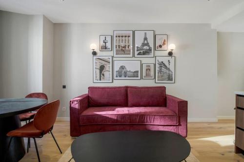 een woonkamer met een rode bank en foto's aan de muur bij 41.Appart 4Pers#1 Bedroom #Père Lachaise #Nation in Parijs