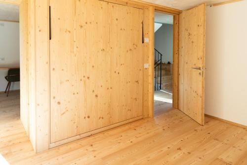 uma porta de madeira num quarto com pisos de madeira em Wome house con idromassaggio em Campo