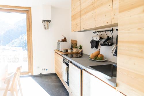 a kitchen with wooden cabinets and a sink at Wome house con idromassaggio in Campo