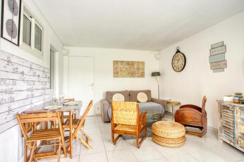 un salon avec un canapé, une table et des chaises dans l'établissement Cocoon Drive - Climatisé avec piscine partagée, à Saint-Raphaël