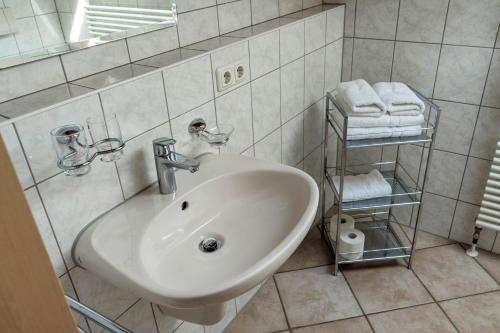 a white sink in a bathroom with towels at Gästehaus Quirin in Garmisch-Partenkirchen