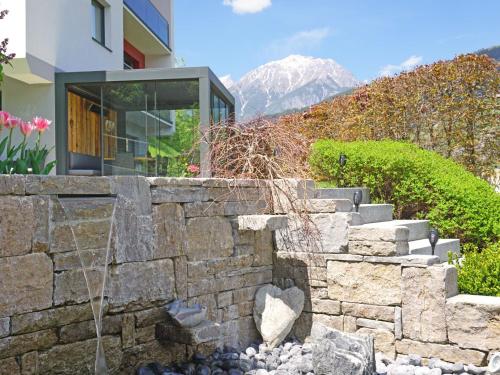 a stone retaining wall with a fountain in front of a building at Apartment Urgbach Apart-1 by Interhome in Landeck