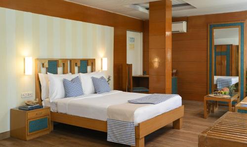 a bedroom with a large bed with blue and white pillows at Soul Vacation Resort and Spa,Colva in Colva