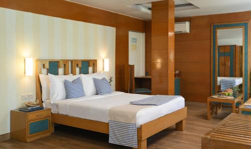 1 dormitorio con 1 cama grande con almohadas azules y blancas en Soul Vacation Resort and Spa,Colva, en Colva