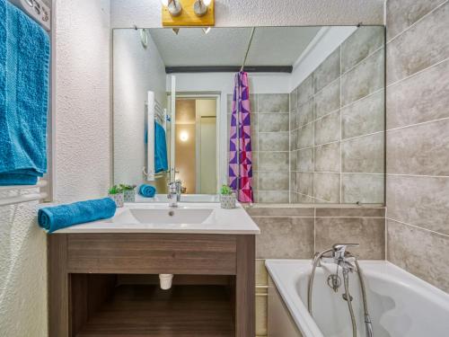 een badkamer met een wastafel en een bad bij Apartment Lunik Orion-41 by Interhome in Le Corbier