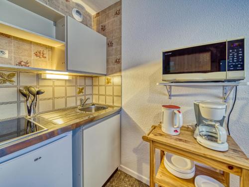 une petite cuisine avec un évier et un micro-ondes dans l'établissement Apartment Argousier 45 A by Interhome, aux Menuires