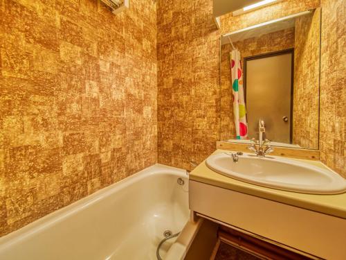 une salle de bain avec un lavabo et une baignoire dans l'établissement Apartment Argousier 45 A by Interhome, aux Menuires