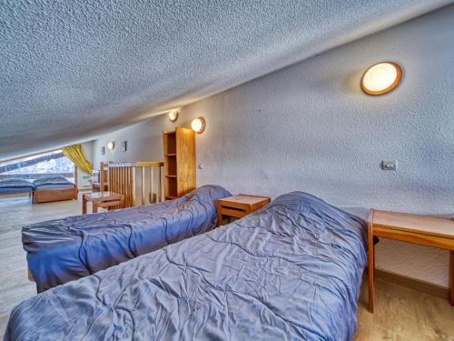 Cette chambre comprend 2 lits et 2 tables. dans l'établissement Apartment Balcon d'Olympie 745 - B by Interhome, aux Menuires