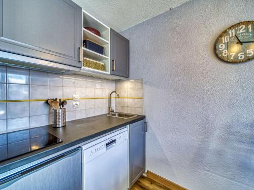 a kitchen with a sink and a clock on the wall at Apartment Balcon d'Olympie 745 - B by Interhome in Les Menuires