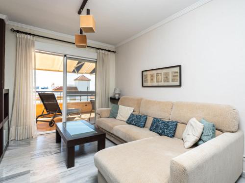 ein Wohnzimmer mit einem Sofa und einem Tisch in der Unterkunft Apartment Bellavista del Puerto by Interhome in Estepona