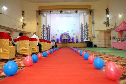 a red and blue aisle with red and blue balloons at Hotel Kumkum Chhaya in Panna