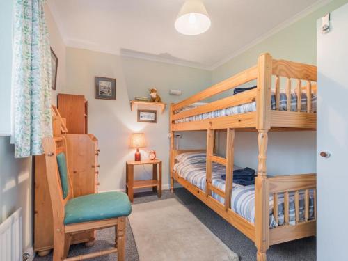 a bedroom with two bunk beds and a chair at 3 Bed in Threlkeld SZ047 in Threlkeld