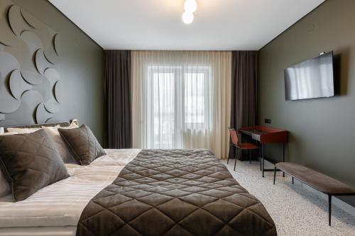 Nizhniy StudenyyにあるOzero Vitaのベッドとデスクが備わるホテルルームです。