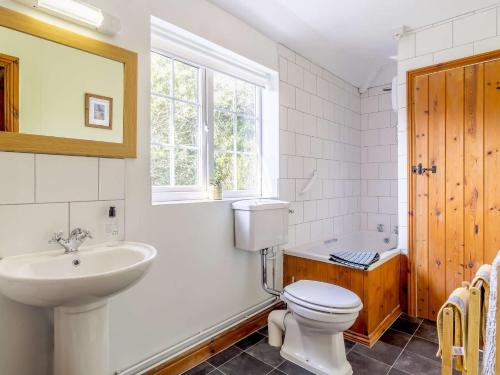 a bathroom with a toilet and a sink and a tub at 1 bed in Wroxham 87415 in Hainford