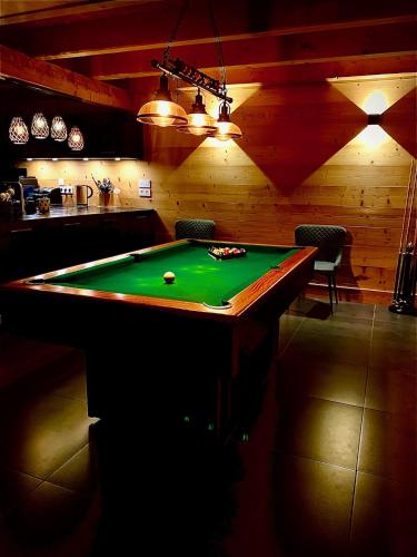 a pool table in a room with a billiard at Nouveau Chalet M.META 12 pers sauna,jacuzzi,billard in Xonrupt-Longemer