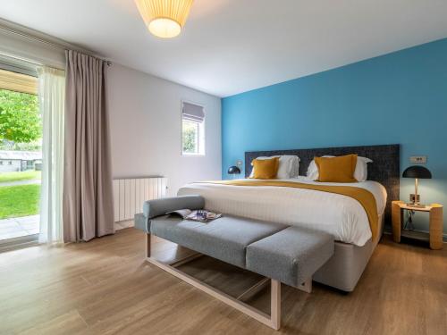 a bedroom with a large bed and a blue wall at 2 Bed in St. Mellion 87703 in St Mellion