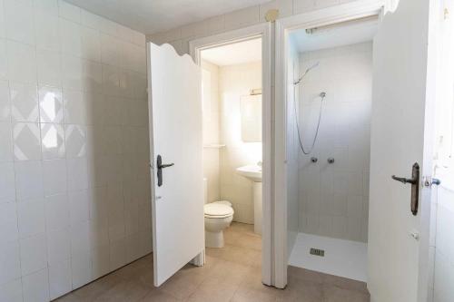 a white bathroom with a toilet and a shower at rentafive - Nuevo - A/A - Barbacoa - Tenis in Santa Pola