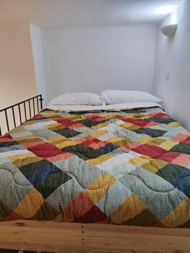 - une couette colorée sur un lit dans une chambre dans l'établissement La casa di Bibi, à Gênes