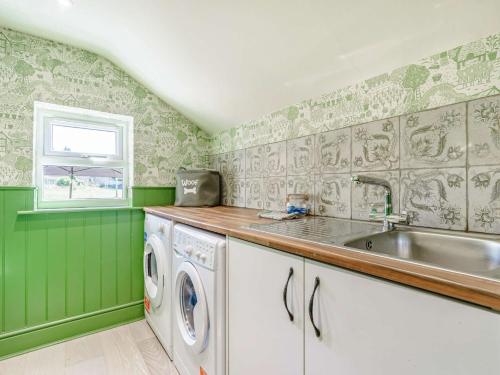a green kitchen with a sink and a washing machine at 2 Bed in Richmond 88217 in Barton