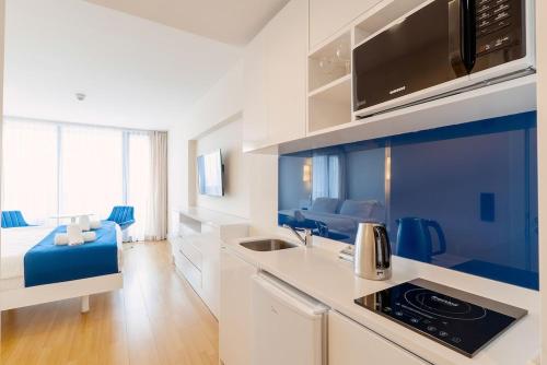 a blue and white kitchen with a couch in a room at Orbi City Hotel VIP - Batumi in Batumi