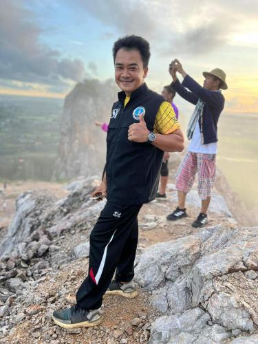 a man standing on top of a mountain at โฮมสเตย์บ้านนายสิงโตเขาคูหา in Ban Khu Ha Nai (1)