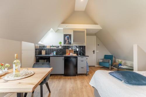 a room with a kitchen and a table in a attic at B&B Studio/Appartement Bij Zee in Stellendam