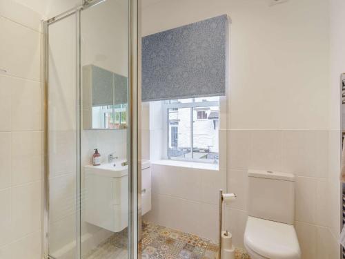 a bathroom with a shower and a toilet and a window at 2 Bed in Askam - in - Furness 88651 in Ireleth