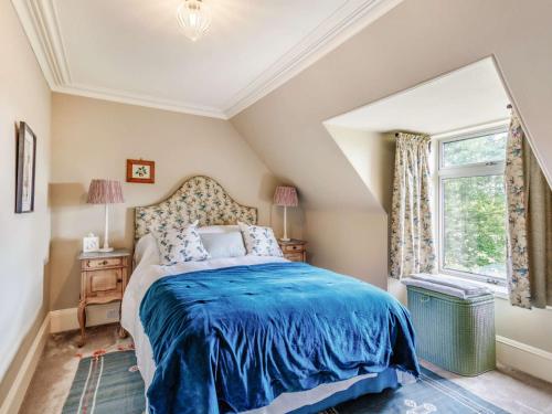 a bedroom with a bed with a blue blanket at 4 Bed in Huntly 88855 in Inverurie