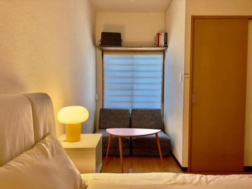 a room with a bed and a table and a window at Cube Stay 北東京 in Tokyo