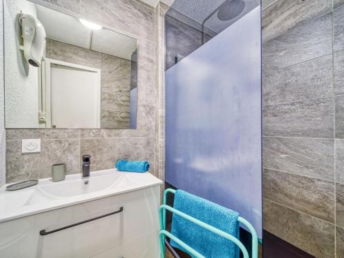 a bathroom with a sink and a mirror at Studio Soyouz Vanguard-100 by Interhome in Le Corbier