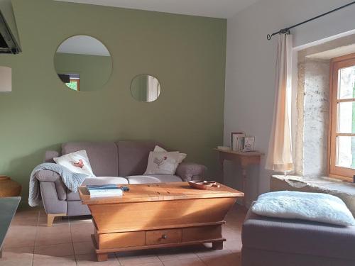 un salon avec un canapé et une table dans l'établissement Charmant Gîte à La Baffe avec Cour Fleurie, Proche Épinal et Gérardmer - FR-1-589-620, à La Baffe