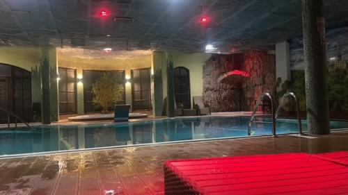 einem Pool mit einer roten Bank in einem Gebäude in der Unterkunft Antonina ***PensjonPrzyKortach*** in Bad Salzbrunn