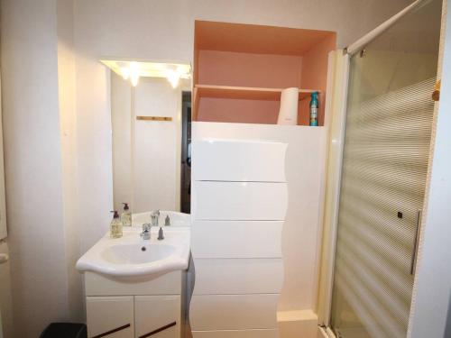 ein weißes Bad mit einem Waschbecken und einer Dusche in der Unterkunft Appartement Bagnères-de-Luchon, 2 pièces, 2 personnes - FR-1-313-229 in Luchon