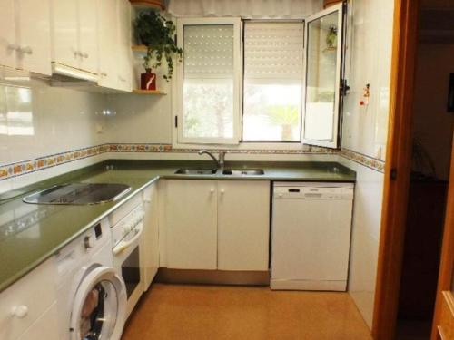 uma cozinha com um lavatório e uma máquina de lavar roupa em Casa Miami Playa, 4 dormitorios, 8 personas - ES-9-161 em L'Hospitalet de l'Infant